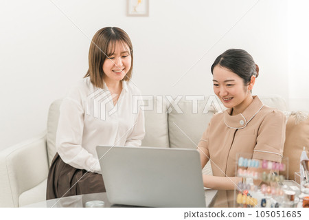 在美甲沙龍使用電腦接受美甲師諮詢的亞洲女性 105051685