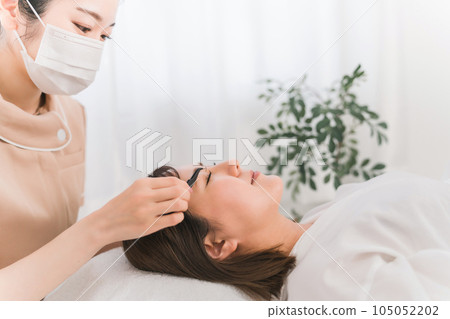 Eyelist performing eyelash extensions 105052202