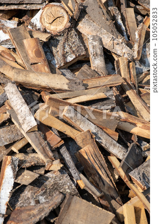 A large pile of different sawn firewood for the stove. Preparing firewood for the winter. Firewood background. 105052833