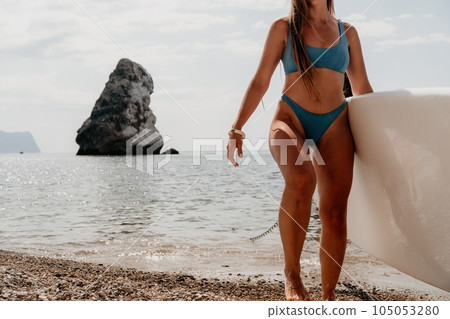Woman sea sup. Close up portrait of happy young caucasian woman with long hair looking at camera and smiling. Cute woman portrait in bikini posing on sup board in the sea Woman sea sup. Close up portrait of happy young caucasian woman with long hair looking at camera and smiling. Cute woman portrait in bikini posing on sup board in the sea 105053280