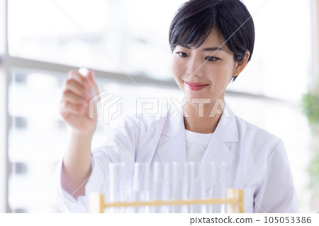 Research image Researcher looking at a test tube Research image Researcher looking at a test tube 105053386