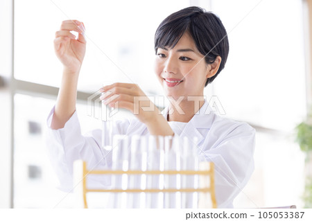 Research image Researcher looking at a test tube Research image Researcher looking at a test tube 105053387