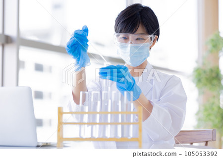 Research image Researcher looking at a test tube 105053392