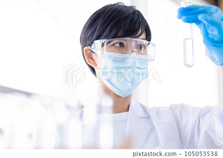 Research image Researcher looking at a test tube Research image Researcher looking at a test tube 105053538