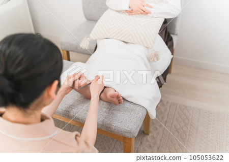 A woman and a manicurist who exfoliate the soles of the feet at a nail salon 105053622