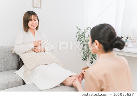 一位女士和一位美甲師在美甲沙龍做修腳和腳趾甲 一位女士和一位美甲師在美甲沙龍做修腳和腳趾甲 105053627