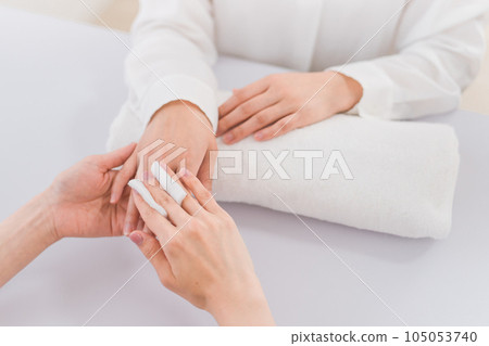 Manicurist and Asian woman removing nails with acetone at nail salon Manicurist and Asian woman removing nails with acetone at nail salon 105053740