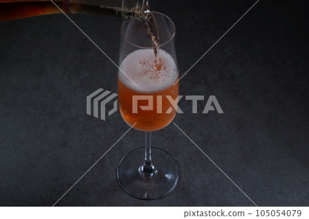 將冷藏好的桃紅香檳(起泡酒)倒入長笛杯中 將冷藏好的桃紅香檳(起泡酒)倒入長笛杯中 105054079