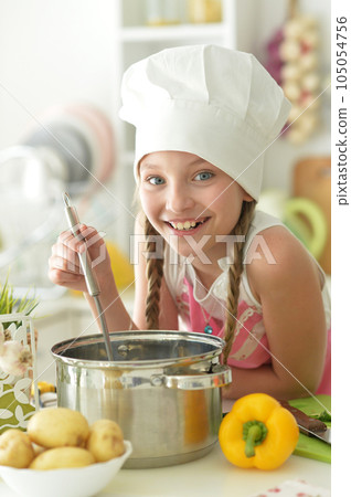 Portrait of cute happy girl coocking on kitchen Portrait of cute happy girl coocking on kitchen 105054756