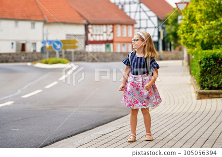 Little Preschool Girl on the Way to School. Healthy Happy Child Walking to Nursery School and Kindergarten. Smiling Child with Eyeglasses and Backpack on the City Street, Outdoors. Back to School. Little Preschool Girl on the Way to School. Healthy Happy Child Walking to Nursery School and Kindergarten. Smiling Child with Eyeglasses and Backpack on the City Street, Outdoors. Back to School. 105056394