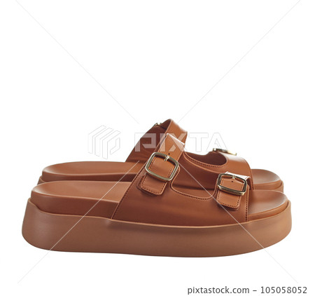 Beautiful pair of women's reddish-colored genuine leather flip-flops with soft soles, isolated on a white background. Side view. The trend of the season. 105058052
