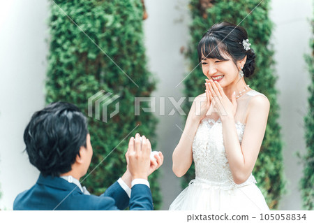 一位身穿婚紗、面帶微笑的亞洲女性/新娘在求婚時收到戒指/訂婚戒指 105058834