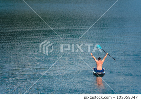 man on paddleboard in the middle of the lake 105059347