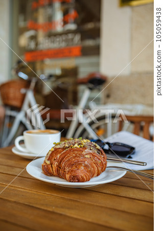 Morning coffee and croissant with reading material Morning coffee and croissant with reading material 105059438