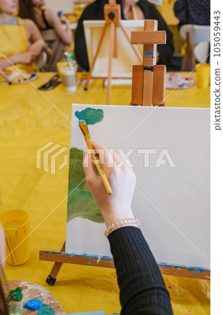 woman hand holding brush paint on canvas 105059443