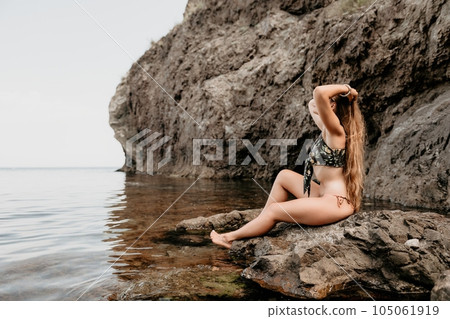 Woman travel sea. Happy tourist enjoy taking picture outdoors for memories. Woman traveler swim in the sea bay with mountains, sharing travel adventure journey 105061919