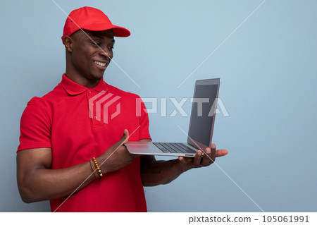 young american man dressed in a baseball cap and t-shirt uniform repairing a laptop young american man dressed in a baseball cap and t-shirt uniform repairing a laptop 105061991