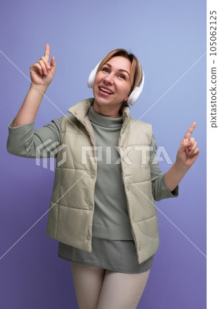 portrait of blond millennial woman with wireless headphones on studio background portrait of blond millennial woman with wireless headphones on studio background 105062125