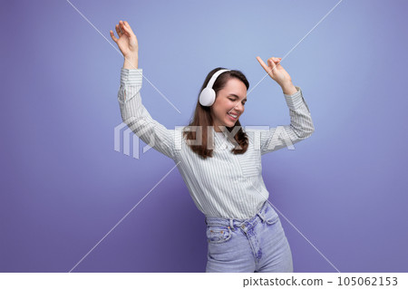 European slender young brown-haired woman breaks off to music from wireless headphones European slender young brown-haired woman breaks off to music from wireless headphones 105062153