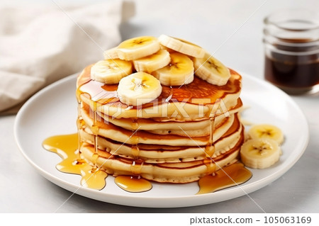 A mountain of pancakes with banana and honey A mountain of pancakes with banana and honey 105063169