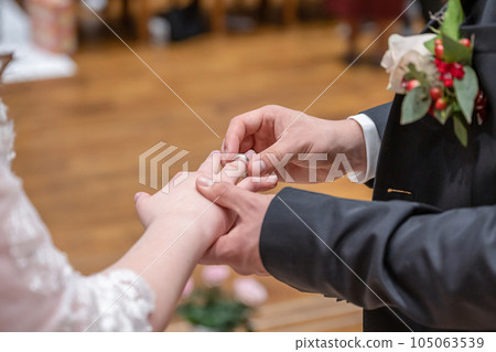wedding rings and hands of bride and groom ring exchange couple at ceremony in love 105063539