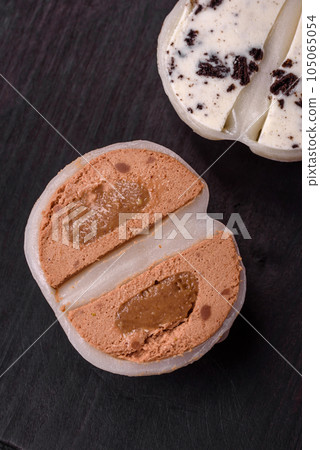 Delicious sweet mochi dessert with toppings on a dark concrete background 105065054
