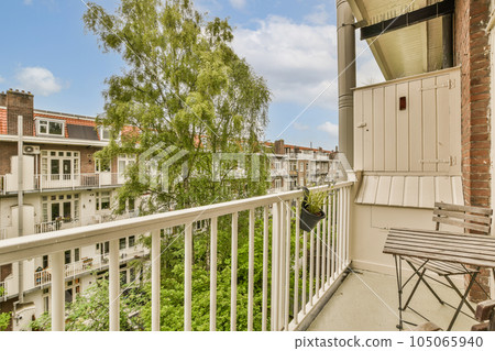 a balcony with trees and buildings in the background on a sunny day, as seen from an apartment's balcony a balcony with trees and buildings in the background on a sunny day, as seen from an apartment's balcony 105065940