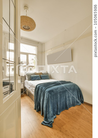 a bedroom with wood flooring and a blue blanket on the bed in front of the door to the room a bedroom with wood flooring and a blue blanket on the bed in front of the door to the room 105065986