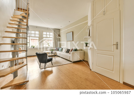 a living room with wood flooring and stairs leading up to the second floor in an apartment, london, england 105065987