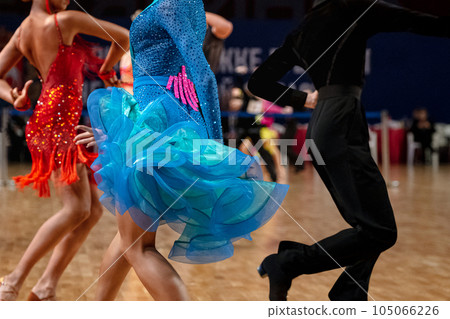 female dancers in red and blue dress and man in black dress, dancesport competition, latino dance 105066226