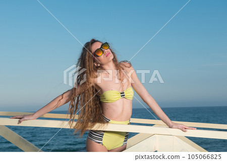 Young woman in swimsuits in the afternoon sun in a coastal area 105066825