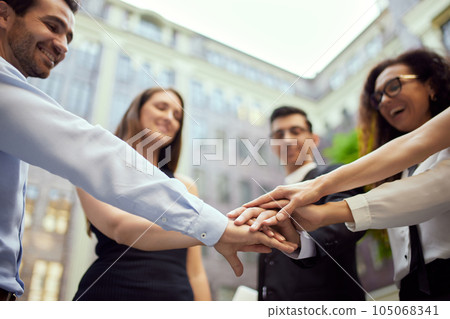 Successful teamwork and connection. Business people holding hands together for good and well-coordinated teamwork 105068341