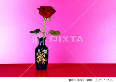 Blue Decorated Flower Vase with Red Rose on a Red Surface and Pink Background Blue Decorated Flower Vase with Red Rose on a Red Surface and Pink Background 105068640