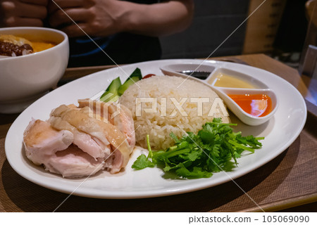 Khao Man Gai from Singapore. A dish of steamed chicken dipped in sauce. Khao Man Gai from Singapore. A dish of steamed chicken dipped in sauce. 105069090