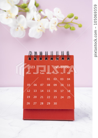 The Red calendar November 2023. Desk calendar for year 2023 and white orchid. 105069359