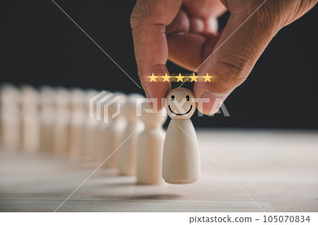Man hand clutches wooden human figure. HR officer seeks leader and CEO. Leader steps out of the crowd. Personal development, motivation, challenge. HR, HRM, HRD concepts. 105070834