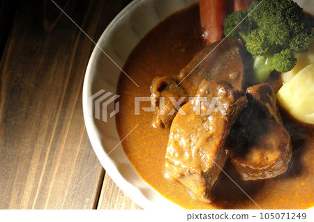 A bird's-eye view of a piping hot beef stew with broccoli, carrots, and potatoes 105071249