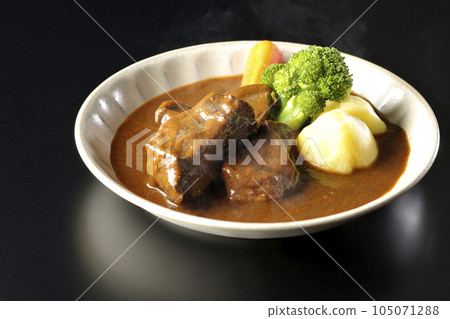Hot beef stew with broccoli, carrots and potatoes, shot against a black background 105071288