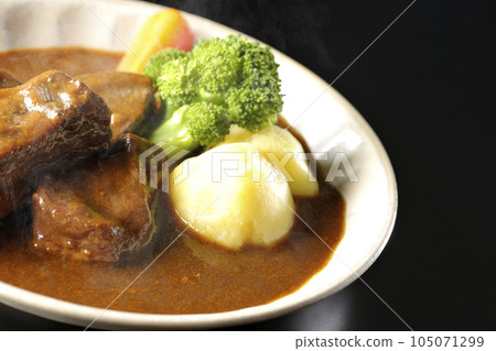 黑色背景下拍攝的熱燉牛肉,配西蘭花、胡蘿蔔和土豆 黑色背景下拍攝的熱燉牛肉,配西蘭花、胡蘿蔔和土豆 105071299