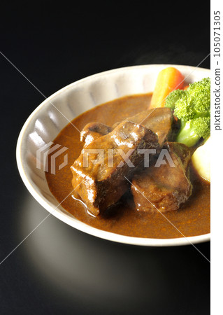 黑色背景下拍攝的熱燉牛肉,配西蘭花、胡蘿蔔和土豆 黑色背景下拍攝的熱燉牛肉,配西蘭花、胡蘿蔔和土豆 105071305