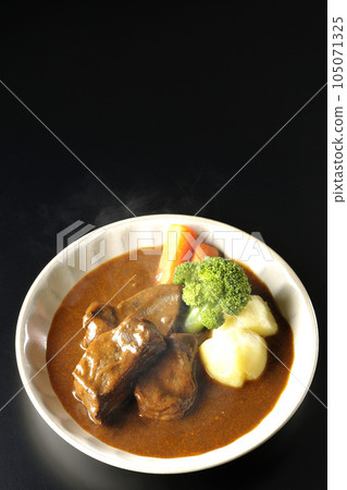 黑色背景下的熱牛肉燉菜、西蘭花、胡蘿蔔和土豆的鳥瞰圖 105071325