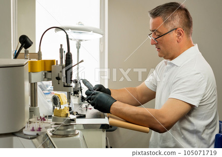 Dental technician working with tooth denture Dental technician working with tooth denture 105071719