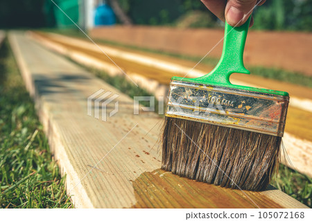 coating wooden boards with an antiseptic with a brush. construction 105072168