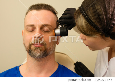 Dermatologist examines moles and birthmarks Dermatologist examines moles and birthmarks 105072467