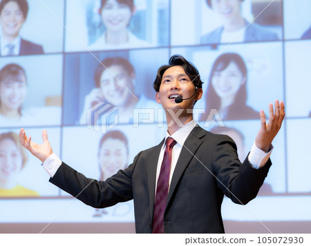 一位男講師在大廳里為通過可視電話與觀眾連接的人進行講座 一位男講師在大廳里為通過可視電話與觀眾連接的人進行講座 105072930
