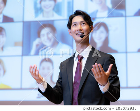 A male lecturer giving a lecture to a person who is connected to the audience by videophone in the hall A male lecturer giving a lecture to a person who is connected to the audience by videophone in the hall 105072933