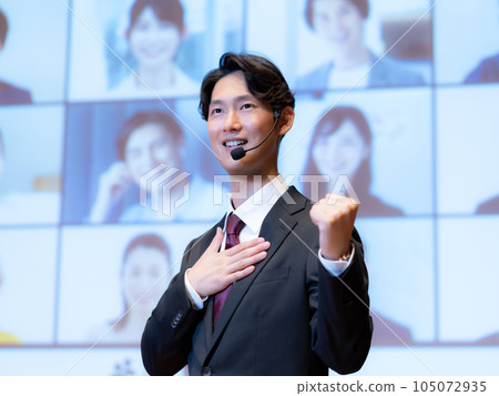 A male lecturer giving a lecture to a person who is connected to the audience by videophone in the hall A male lecturer giving a lecture to a person who is connected to the audience by videophone in the hall 105072935