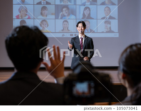 A young man asking a question in the hall and a lecturer on stage 105073041