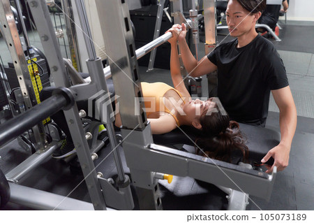 在健身房訓練的女性和支持她的教練 105073189