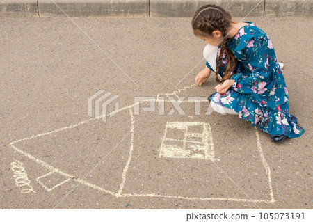 Junior school girl draws windows and curtains of house 105073191